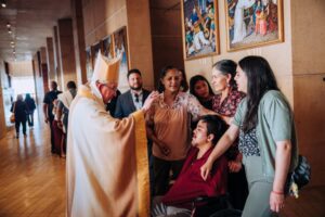 ABGAnniversaryMass-84-web-768x512 | Angelus en Español El arzobispo Gómez bendice a una familia después de la Misa del 26 de marzo de 2026. (Isabel Cacho)