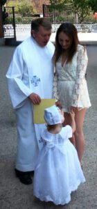 Megan Trembley posa con el párroco de Corpus Christi, Mons. Liam Kidney, después del bautismo de su hija en 2016. (Foto proporcionada)