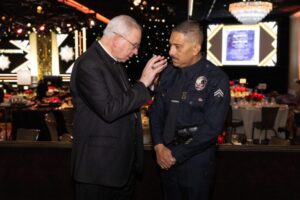 El arzobispo Gomez bendice a un sargento del Departamento de Policía de Los Ángeles que asistió a la cena de los Premios del Arzobispo 2026. También estuvo presente el jefe de policía Jim McDonnell. (Javier De León)