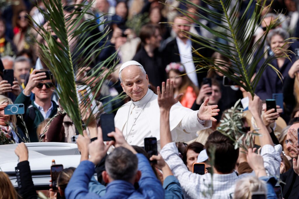 El papa León XIV reacciona al pasar junto a personas que sostienen ramas tras la misa del Domingo de Ramos en la Plaza de San Pedro, en el Vaticano, el 29 de marzo de 2026. El papa León lavará los pies a 12 sacerdotes el Jueves Santo durante la «In Coena Domini» —la misa del Jueves Santo de la Última Cena— el 2 de abril en la basílica de San Juan de Letrán. (OSV News/Remo Casilli, Reuters)