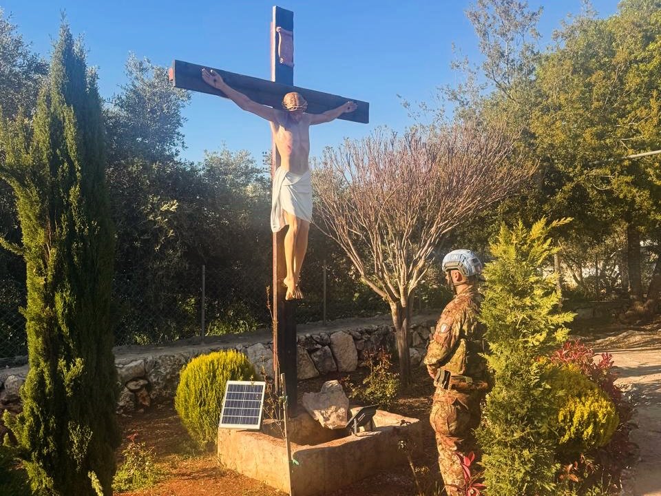 Un soldado italiano de la fuerza de paz de la ONU reza ante la nueva estatua de Cristo en la cruz erigida en la localidad de Debel, Líbano, el 22 de abril de 2026. La nueva estatua sustituye a la que resultó dañada unos días antes, cuando un soldado de las Fuerzas de Defensa de Israel la golpeó con el lado romo de un hacha, lo que provocó la indignación internacional por tal profanación. (Foto de OSV News/cortesía de Debel Alert)