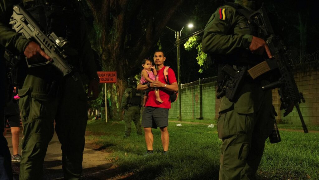 Un hombre sostiene a un niño mientras observa a la candidata presidencial colombiana Paloma Valencia durante una conferencia de prensa en Palmira el 25 de abril de 2026, tras un atentado con explosivos en una carretera en la provincia suroccidental de Cauca. Durante su audiencia del 29 de abril, el Papa León XIV pidió el fin de la violencia tras conocer el ataque que dejó 20 muertos y decenas de heridos. (Foto OSV News/Jair Coll, Reuters)