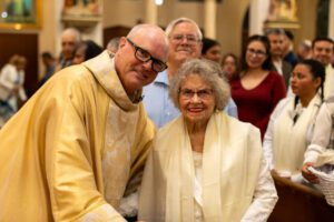 El padre John Love, párroco de la iglesia Santa Clara en Oxnard, junto a Eidson durante la Vigilia Pascual tras ser recibida en la Iglesia Católica. (Noah Tyler Tabbay/Iglesia Santa Clara)