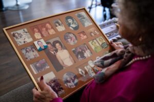 Eidson sostiene un marco con fotos familiares de varios años en su casa en Oxnard. (Reese Cuevas)