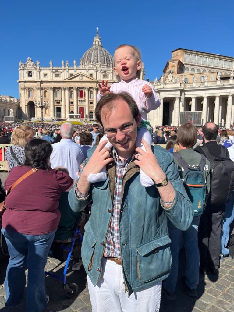 El autor junto a su hija en la plaza de San Pedro la mañana de Pascua de 2026, para recibir la bendición urbi et orbi (“a la ciudad y al mundo”) del papa León XIV. (Nic Rowan)