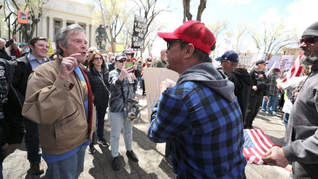 Dos manifestantes con posturas opuestas se enfrentan mientras una multitud se reúne frente al tribunal en Prescott, Arizona, el 5 de abril de 2025, para protestar contra la administración del presidente de Estados Unidos, Donald Trump. (Foto OSV News/Bob Roller)