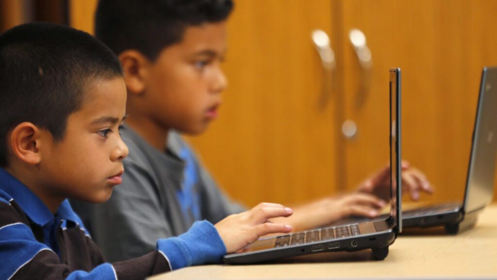 Alumnos de cuarto grado trabajan con computadoras portátiles en la escuela Monarch de San Diego, en una foto de archivo. (OSV News photo/Mike Blake, Reuters)
