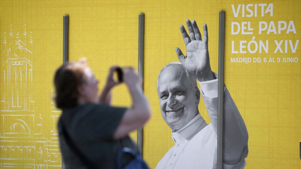 Una mujer toma una fotografía de un cartel del Papa León XIV en Madrid el 28 de mayo de 2026, antes de la visita apostólica del pontífice a España, prevista del 6 al 12 de junio. (Foto de OSV News/Kacper Pempel, Reuters)