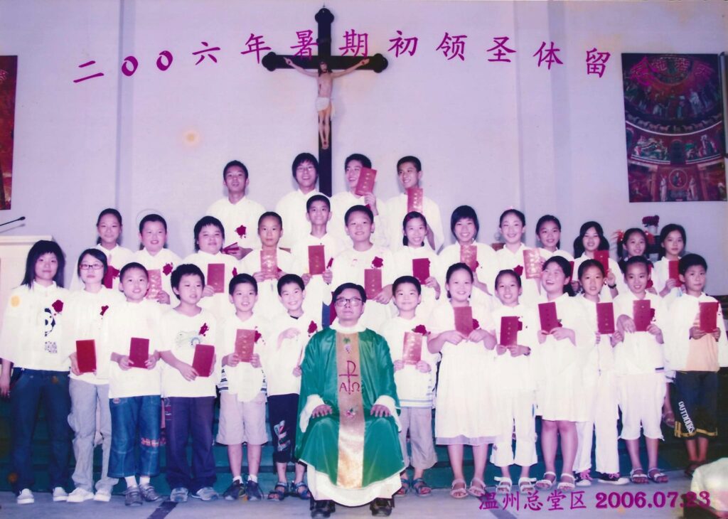 Shengda (Martin) Zhu posa durante su primera comunión en China. Zhu está de pie a la derecha del sacerdote. (Foto enviada)