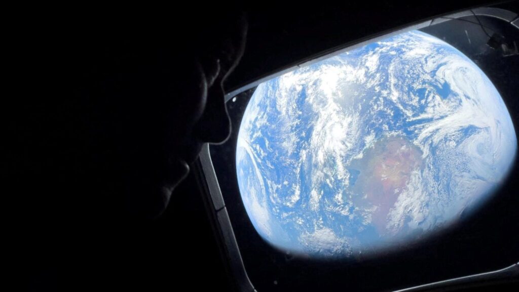 El astronauta de la NASA y comandante de Artemis II, Reid Wiseman, observa a través de una de las ventanas principales de la cabina de la nave Orion el 2 de abril, mientras mira hacia la Tierra durante el trayecto de la tripulación rumbo a la Luna. (OSV News/NASA vía Reuters)