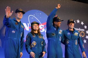 Los astronautas Jeremy Hansen, de la Agencia Espacial Canadiense, y Christina Koch, Victor Glover y Reid Wiseman, de la NASA, saludan a la multitud en el Aeropuerto Ellington, en Houston, el 11 de abril, tras regresar de la misión Artemis II, que orbitó la Luna a bordo de la cápsula Orion. La misión Artemis II de la NASA llevó a los cuatro astronautas en un viaje de casi 10 días alrededor de la Luna y de regreso a la Tierra, culminando con un amerizaje en el océano Pacífico el 10 de abril. (OSV News/Lexi Parra, Reuters)