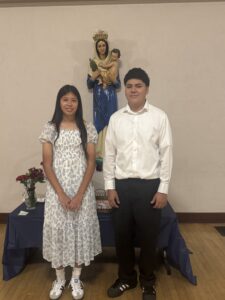 Eighth-graders Sophia Diaz and Emmanuel Mendoza at Notre Dame School in Santa Barbara pose with the crowned Virgin Mary statue during a May crowning event. (Notre Dame School)