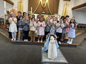 The kindergarten class at St. Raphael School in Santa Barbara poses around a doll of the Virgin Mary for their May crowning event. (St. Raphael School)