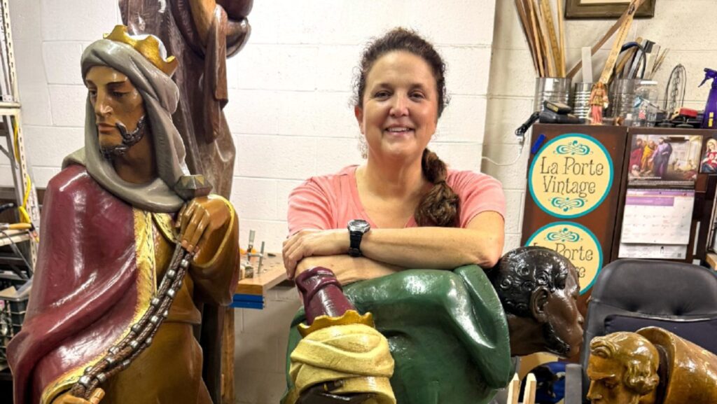 Sheila Lehman, restauradora de La Porte Vintage en Arcadia y feligresa de la iglesia St. Bede the Venerable en La Cañada Flintridge, posa junto a algunas de las figuras del pesebre que está restaurando para la Catedral de Nuestra Señora de los Ángeles. (La Porte Vintage)