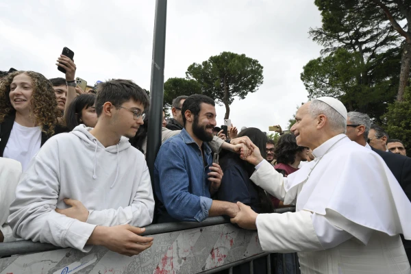 El Papa saluda a unos jóvenes en la universidad. Crédito: Vatican Media