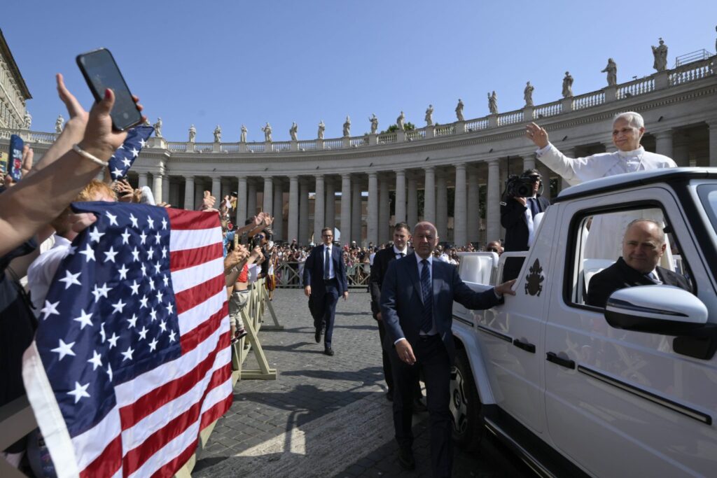 El papa León XIV saluda a peregrinos que portan una bandera de Estados Unidos al llegar en el papamóvil a la Plaza de San Pedro para la audiencia general del 18 de junio de 2025, en el Vaticano. (Foto de CNS/Vatican Media)