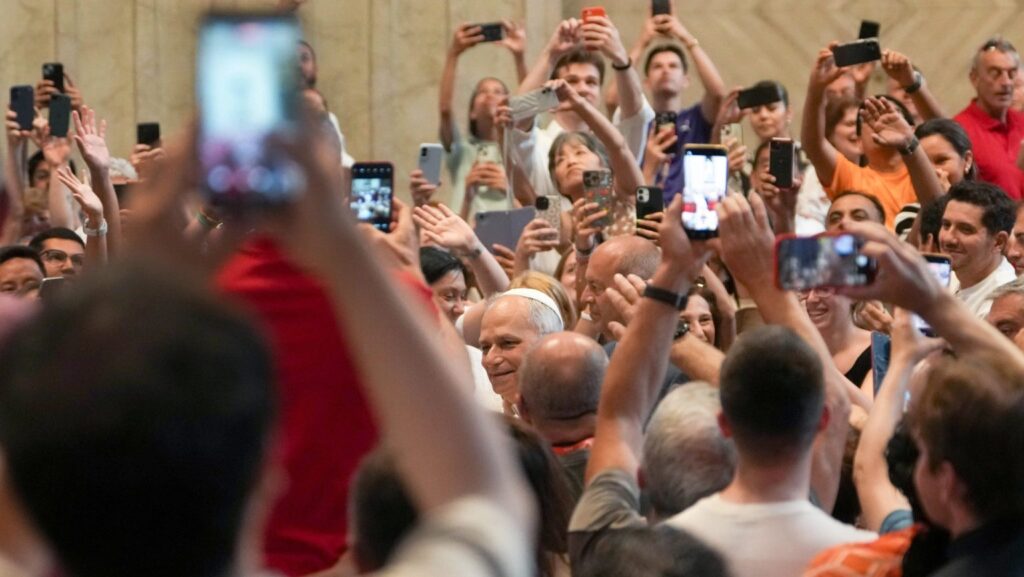 En esta foto de archivo del 14 de junio de 2025, el papa León XIV saluda a los fieles mientras estos levantan sus teléfonos celulares para tomar fotos y videos, al ingresar a la Basílica de San Pedro para un encuentro con peregrinos que se encuentran en Roma con motivo del Año Santo 2025. (CNS/Lola Gómez)