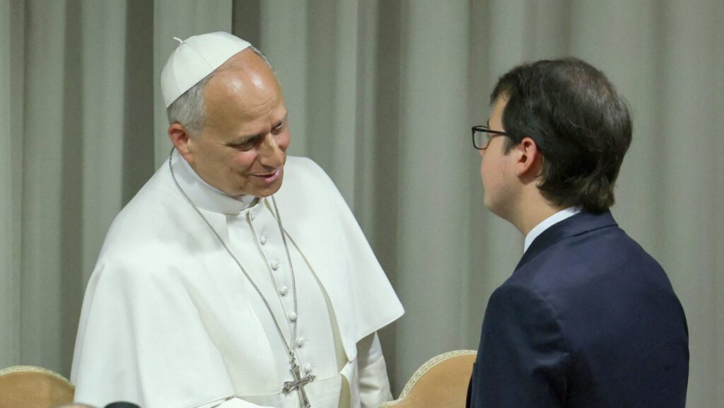 El papa León XIV estrecha la mano de Christopher Olah, cofundador de la empresa estadounidense de inteligencia artificial Anthropic, durante la presentación de Magnifica Humanitas en el Aula del Sínodo del Vaticano el 25 de mayo. (OSV News/Yara Nardi, Reuters)