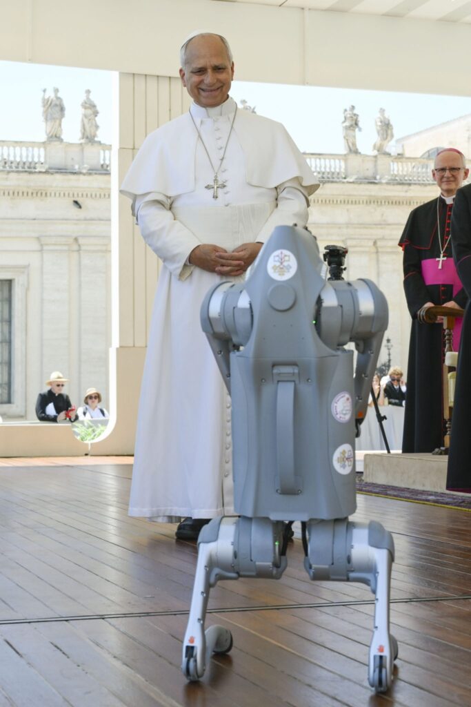 El papa León XIV observa con interés un “perro robot” que le fue presentado tras la audiencia general semanal en la Plaza de San Pedro del Vaticano, el 27 de mayo. (OSV News/Elisabetta Trevisan, Vatican Media)
