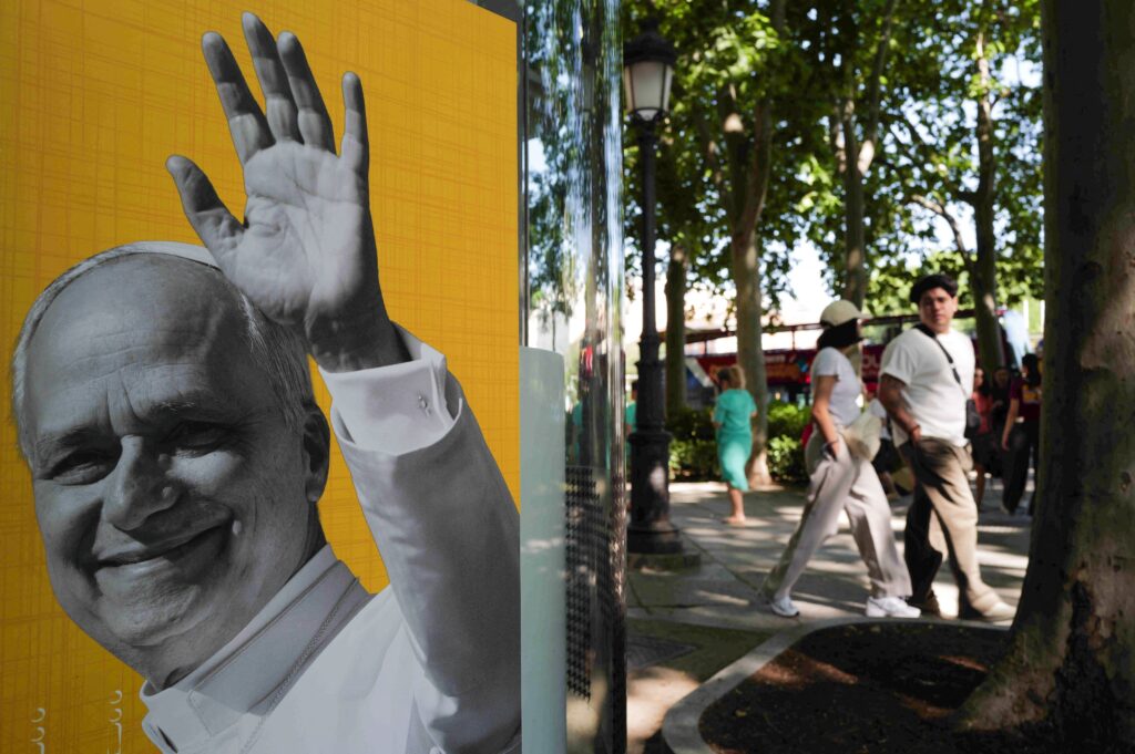 Personas pasan junto a un cartel del Papa León XIV en Madrid el 28 de mayo de 2026, antes de la visita apostólica del pontífice a España, prevista del 6 al 12 de junio. (Foto OSV News/Kacper Pempel, Reuters)