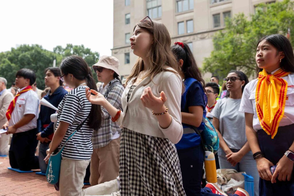 Fieles se arrodillan en oración ante un altar instalado a lo largo del recorrido de una procesión eucarística por las calles de Washington el 6 de junio de 2026. El evento marcó la llegada de la Peregrinación Eucarística Nacional a la capital estadounidense y coincidió con la cuarta procesión eucarística anual organizada por el Centro de Información Católica. (Foto: Mihoko Owada/Catholic Standard).