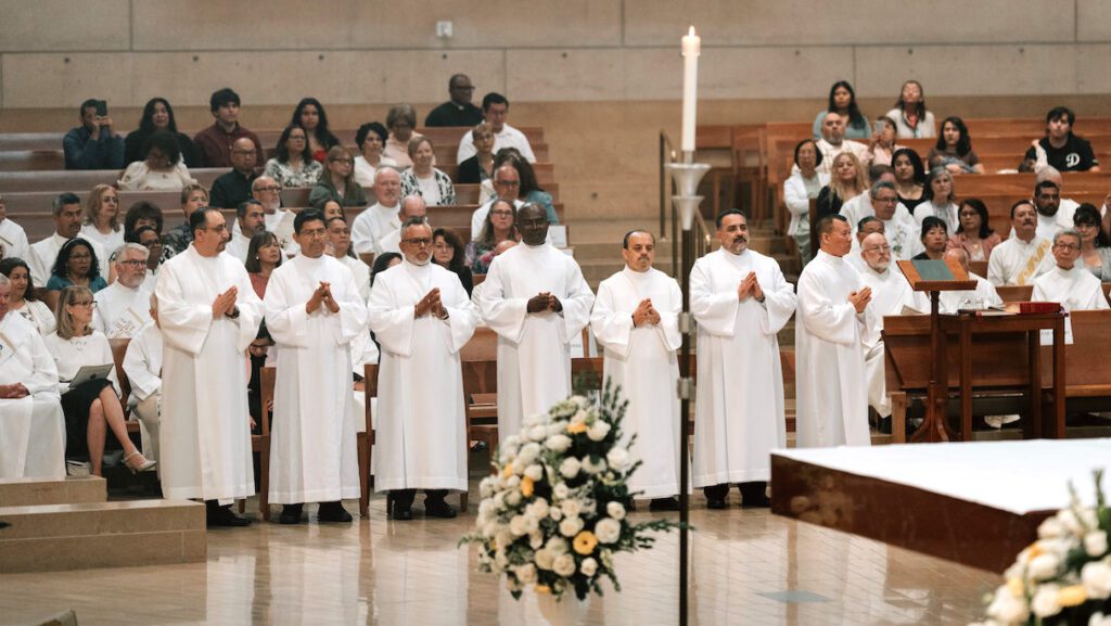Los siete candidatos al diaconado permanente esperan junto al altar el inicio de la misa de ordenación en la Catedral de Nuestra Señora de los Ángeles, el 6 de junio. (Peter Lobato)