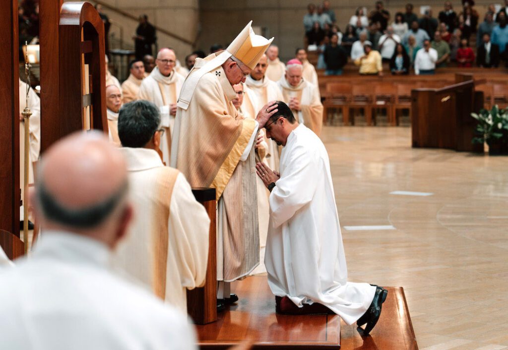 El arzobispo José H. Gomez impone las manos sobre Rubén Quezada durante la misa de ordenación de diáconos permanentes en la Catedral de Nuestra Señora de los Ángeles, el 6 de junio. (Peter Lobato)