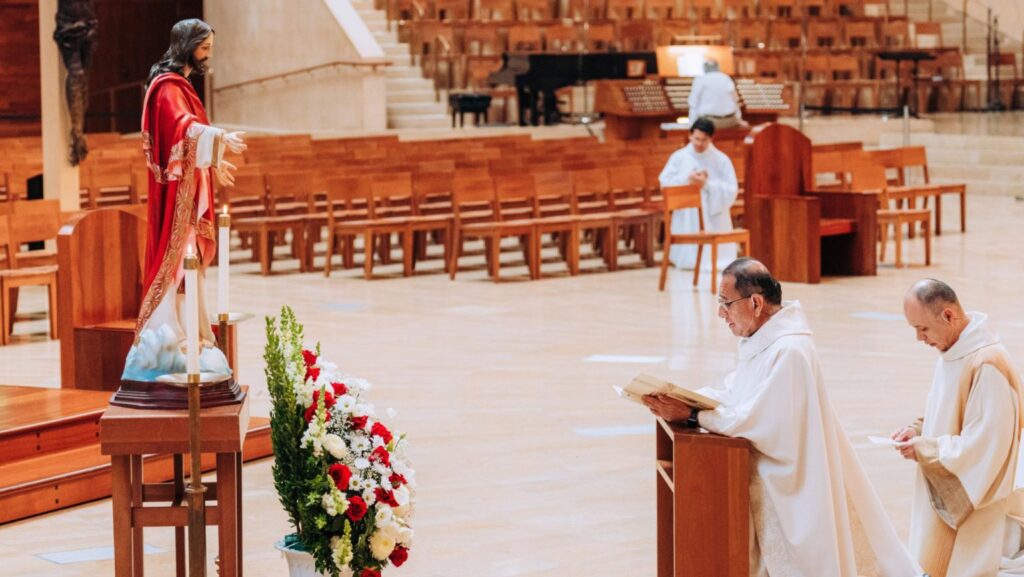 El padre David Gallardo dirige la oración de consagración al Sagrado Corazón de Jesús durante la misa del mediodía celebrada el 12 de junio en la Catedral de Nuestra Señora de los Ángeles. (Isabel Cacho).