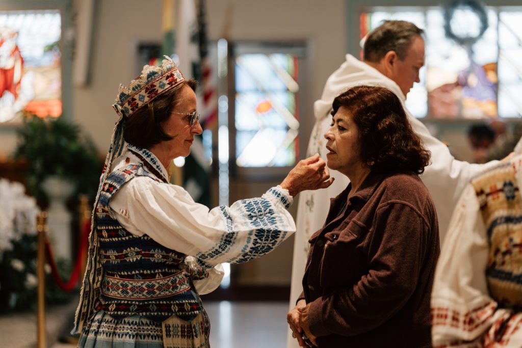 Irene Venckus, con vestimenta tradicional lituana, distribuye la Comunión durante la Misa celebrada en la Iglesia de San Casimiro, en Los Feliz, en el marco de la celebración del aniversario parroquial Atlaidai, el 31 de mayo. (Peter Lobato)