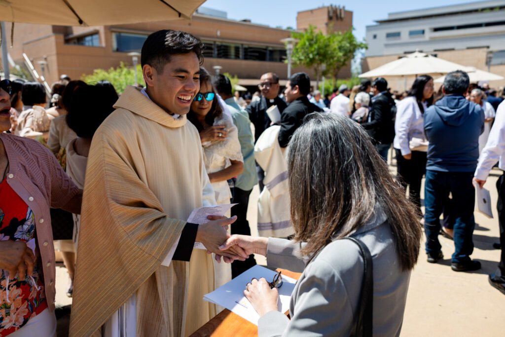 archdiocese-los-angeles-ordination-jpegJoe-706-1536x1024 | Angelus en Español El padre Jerick Alenton saluda a una persona que se acercó a felicitarlo y le imparte su primera bendición tras la Misa de ordenación celebrada el 30 de mayo en la Catedral de Nuestra Señora de los Ángeles. (Joe Garcia III)