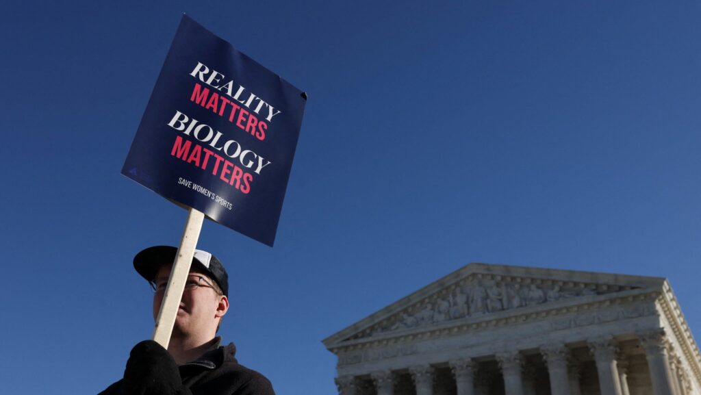 Una persona a favor de que las competencias deportivas femeninas se basen en el sexo biológico sostiene un cartel frente a la Corte Suprema de Estados Unidos, en Washington, D.C., el 13 de enero. (Foto de OSV News/Tyrone Siu, Reuters)