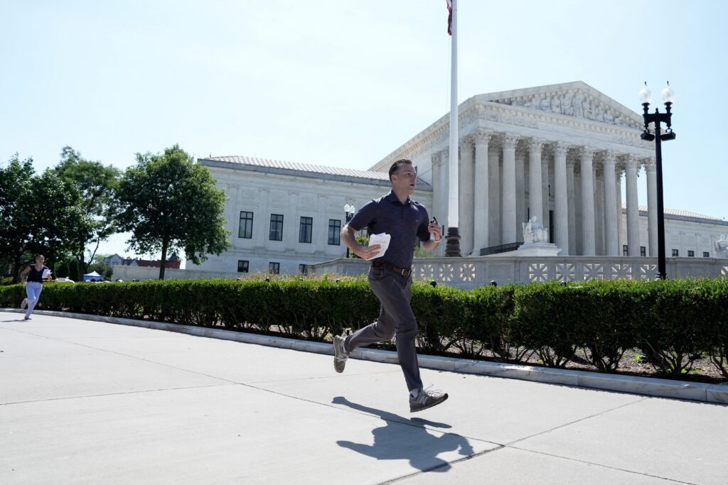 Un asistente sale corriendo del edificio de la Corte Suprema de Estados Unidos, en Washington, el 30 de junio de 2026, para entregar a la prensa el fallo sobre la ciudadanía por nacimiento. El máximo tribunal del país ratificó una interpretación amplia de ese derecho y rechazó la orden ejecutiva del presidente Donald Trump que negaba la ciudadanía estadounidense a los hijos de personas que se encuentran en el país de forma ilegal o temporal. (Foto de OSV News/Cheney Orr, Reuters)