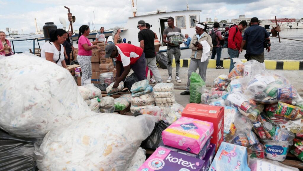 Integrantes de una flotilla que partió de México, junto con trabajadores portuarios locales, descargan ayuda humanitaria a su llegada a la bahía de La Habana el 24 de marzo de 2026. Catholic Relief Services (CRS), la agencia humanitaria y de desarrollo de los obispos católicos de Estados Unidos, recibió 60 millones de dólares del Departamento de Estado de EE.UU. para ampliar la asistencia humanitaria a familias vulnerables en toda Cuba. (Foto de OSV News/Jorge Luis Bañós, pool vía Reuters)
