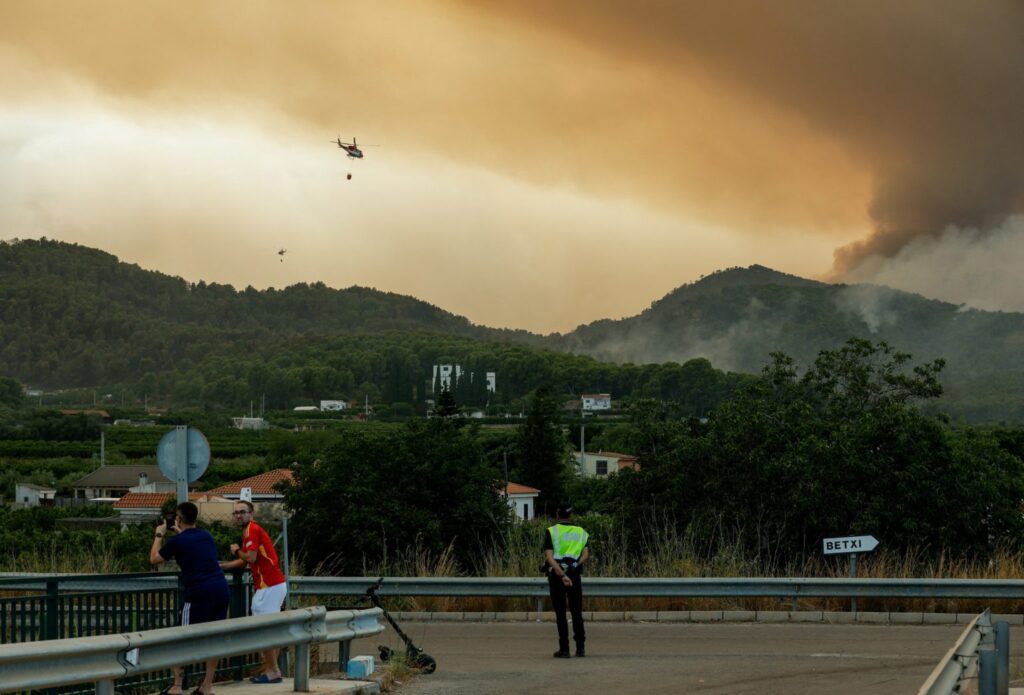 Helicópteros sobrevuelan la zona mientras el humo se eleva por los incendios forestales en Betxí, España, el 26 de julio de 2026. Durante el rezo del Ángelus en la Piazza della Libertà, en Castel Gandolfo, cerca de Roma, ese mismo día, el papa León XIV oró por los bomberos que continúan combatiendo los devastadores incendios en España y Francia, los cuales han obligado a cientos de miles de personas a evacuar sus hogares. (Foto OSV News/Eva Manez, Reuters)