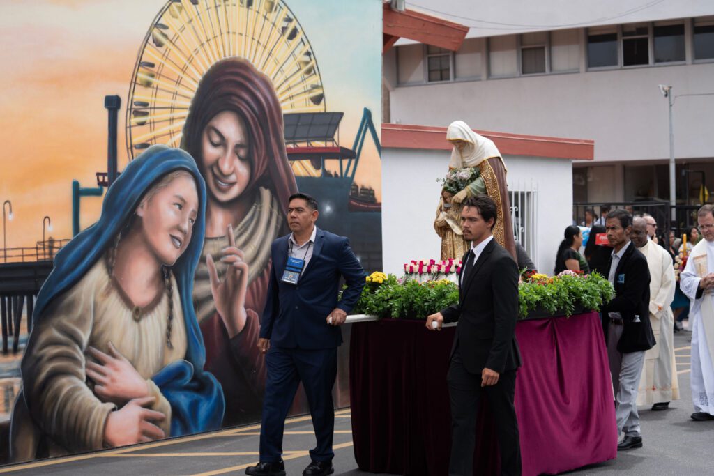 Feligreses participan en una procesión hacia el Santuario de Santa Ana, en Santa Mónica, antes de la misa celebrada el 26 de julio por la festividad de la santa. A la izquierda, un mural inaugurado en 2024 muestra a santa Ana sosteniendo en brazos a su hija, la Santísima Virgen María. (Poncho Romero)