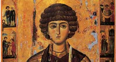 Iconic painting of a young saint with curly dark hair, wearing a brown robe, set against a gold background with small figures along the sides.