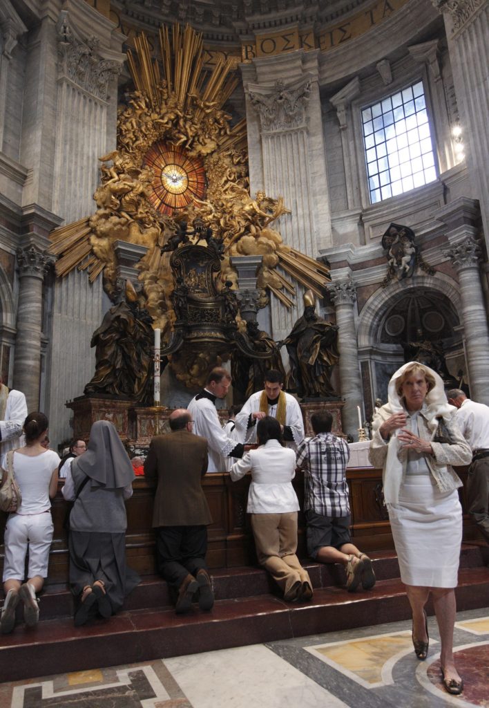 Fieles se arrodillan mientras reciben la Comunión durante una Misa según el rito tridentino, celebrada en el Altar de la Cátedra de la Basílica de San Pedro, en el Vaticano, el 15 de mayo de 2011. Fue la primera vez en varias décadas que este rito se celebró en ese altar. (CNS/Paul Haring)