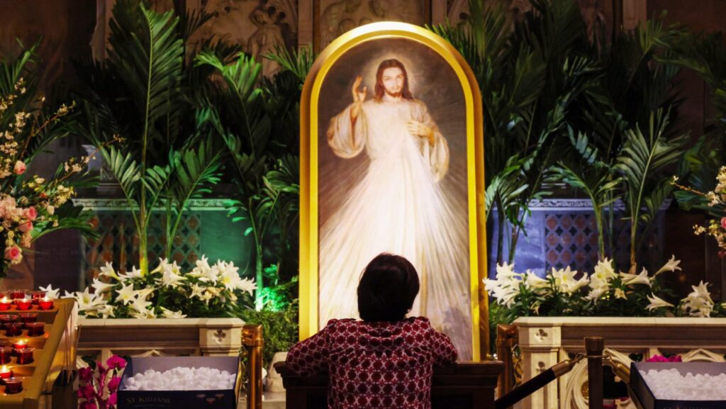 Una mujer se arrodilla para rezar frente a una imagen de la “Divina Misericordia” de Jesucristo en el interior de la Catedral de San Patricio, en Nueva York, el 13 de abril. (OSV News/Shannon Stapleton, Reuters)