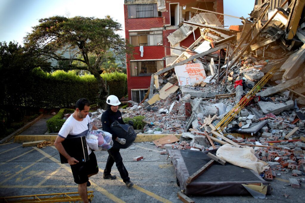 Personas caminan junto a los escombros en Pereira, Colombia, el 11 de agosto de 2026, tras el devastador terremoto de magnitud 7,4 ocurrido el día anterior. (Foto de OSV News/Juan David Duque, Reuters)