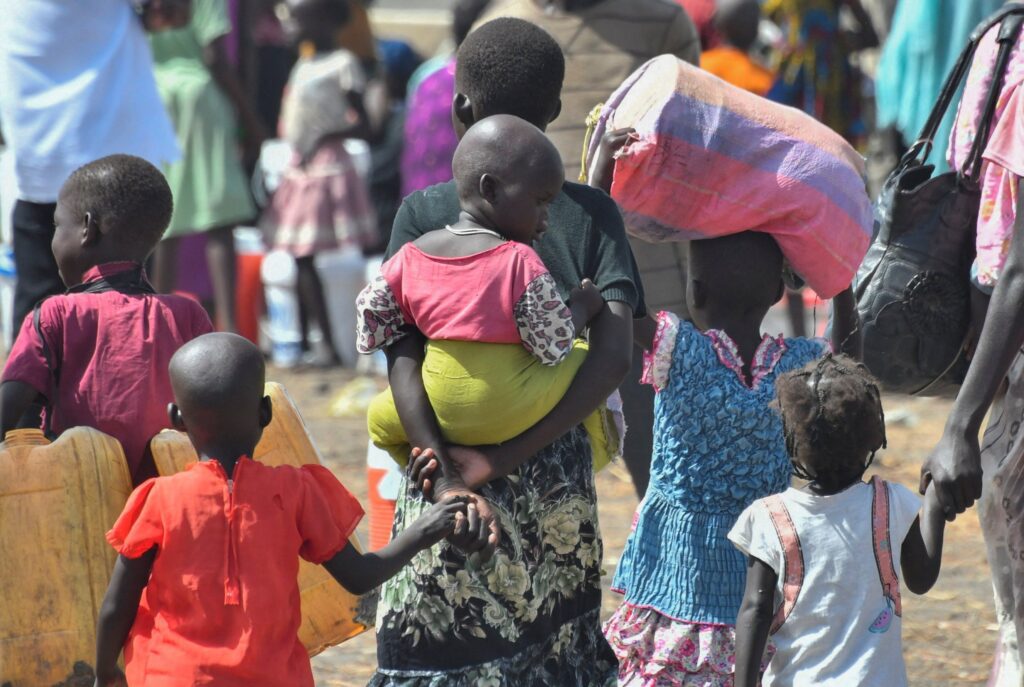 Niños que huyeron del Sudán devastado por la guerra tras el estallido de los combates entre el ejército sudanés y las Fuerzas de Apoyo Rápido (conocidas como RSF), llegan al centro de tránsito del Alto Comisionado de las Naciones Unidas para los Refugiados (ACNUR) en Renk, Sudán del Sur, el 1 de mayo de 2023. (Foto OSV News/Jok Solomun, Reuters)