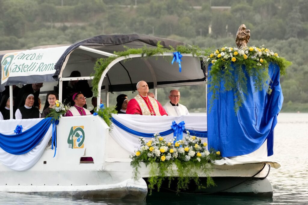 El papa León XIV mira hacia una estatua de Nuestra Señora del Lago mientras una embarcación comienza a navegar por el lago Albano durante una procesión mariana en Castel Gandolfo, Italia, el 29 de agosto de 2026, fiesta de Nuestra Señora del Lago. (Foto CNS/Lola Gomez)