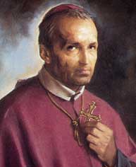 Portrait of a clergyman wearing purple liturgical robes, looking at the viewer and holding a gold cross pendant.