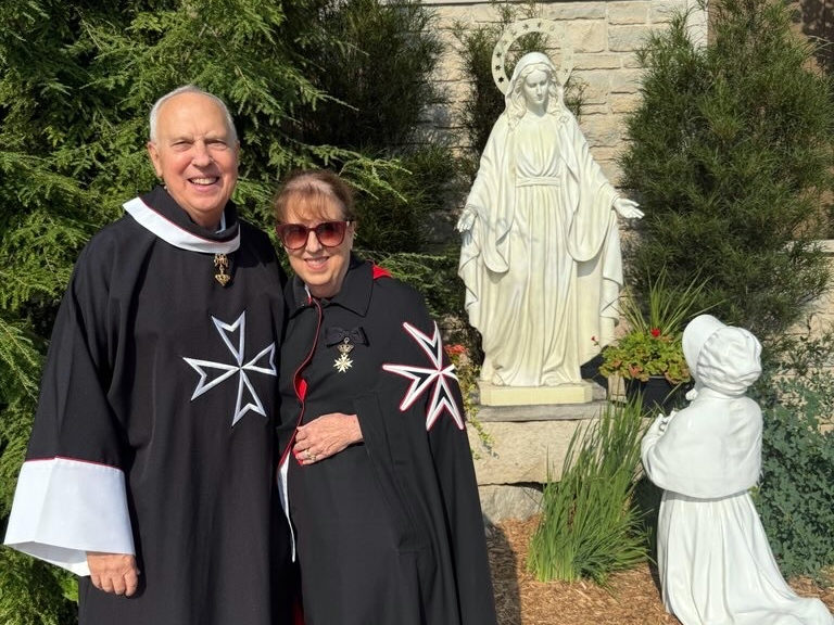 Joe y Ann Sanders, feligreses de la iglesia de San Felipe Apóstol, en Pasadena, y miembros de la Orden de Malta como caballero y dama, posan durante su peregrinación a Champion. (Ann Sanders)