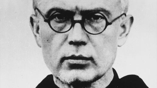 Close-up black-and-white portrait of an older man wearing round glasses and a serious expression.