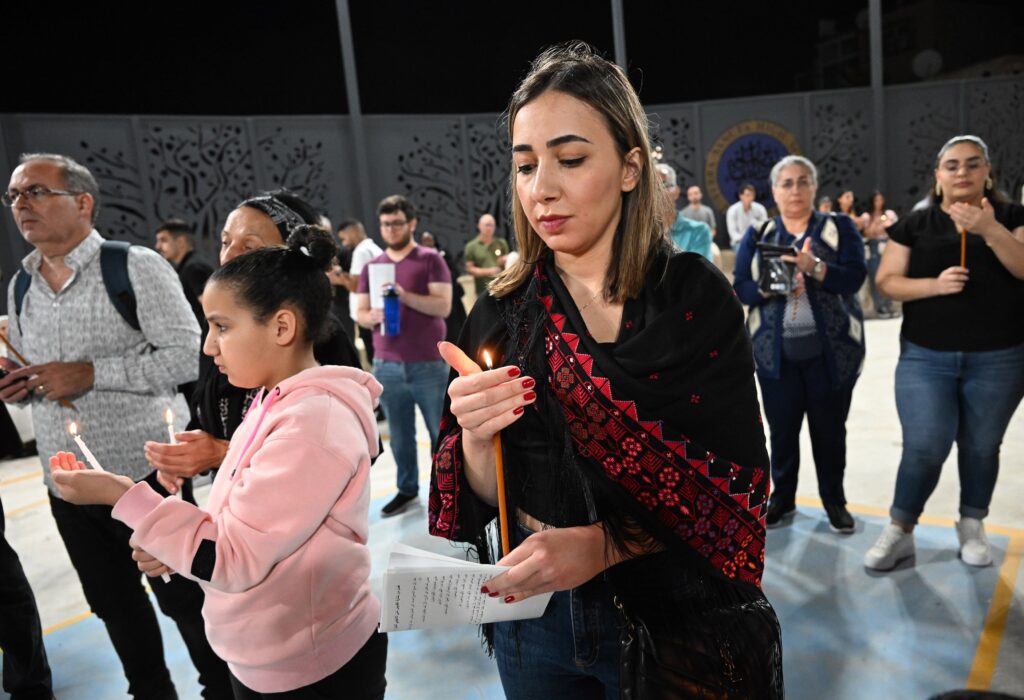 Palestinos cristianos sostienen velas durante una vigilia de oración por la paz en el patio de la Escuela Católica Terra Sancta, en la Ciudad Vieja de Jerusalén, el 9 de noviembre de 2023, en medio de la guerra entre Israel y Hamás. Las autoridades israelíes denegaron permisos de ingreso a decenas de maestros y personal administrativo, lo que obligó a las escuelas cristianas de Jerusalén a suspender el inicio del año académico 2026-2027. (Foto de OSV News/Debbie Hill)