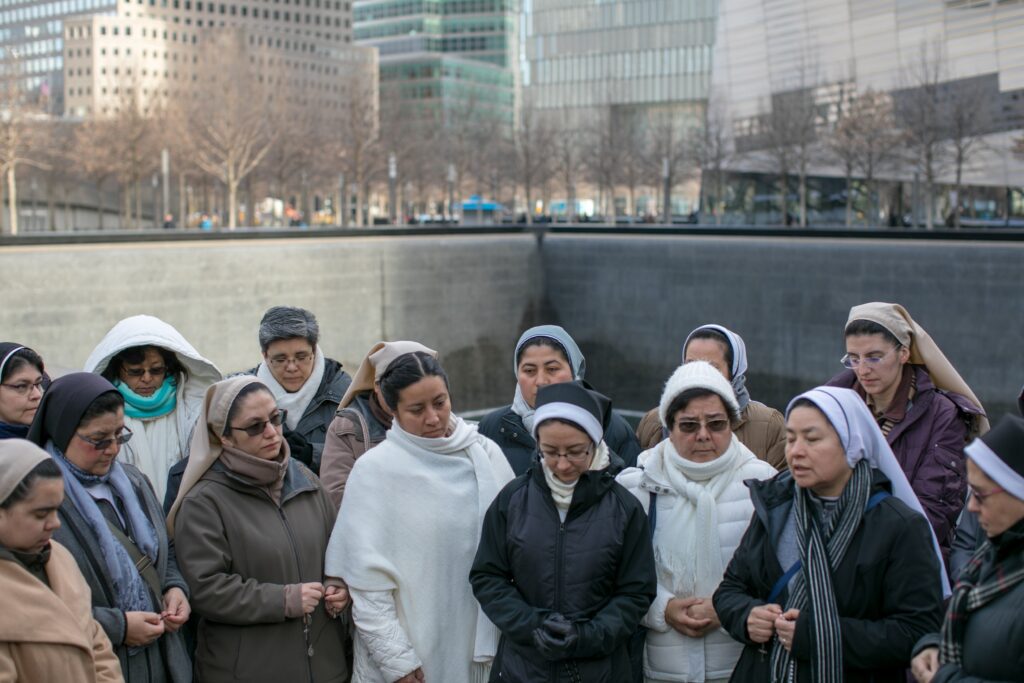 Hermanas misioneras rezan en el Memorial del 11-S durante una visita a la ciudad de Nueva York en 2018. (Foto de OSV News/Catholic Extension)