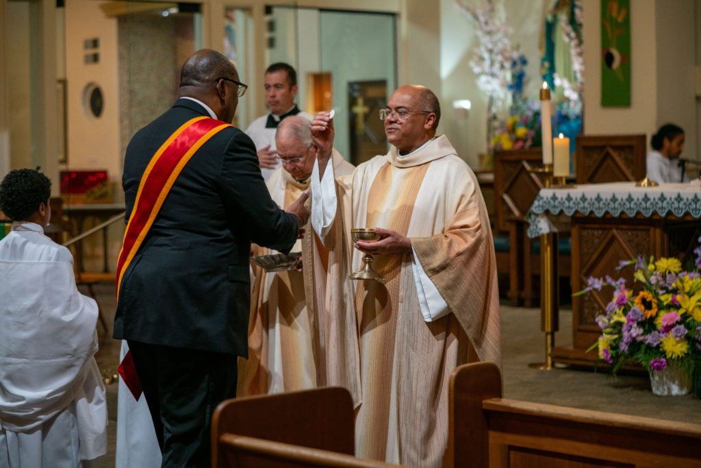 El arzobispo Shelton Fabre de Louisville, capellán supremo nacional de los Caballeros, da la Sagrada Comunión a F. DeKarlos Blackmon durante la Misa del 6 de septiembre de 2026. (John Rueda)