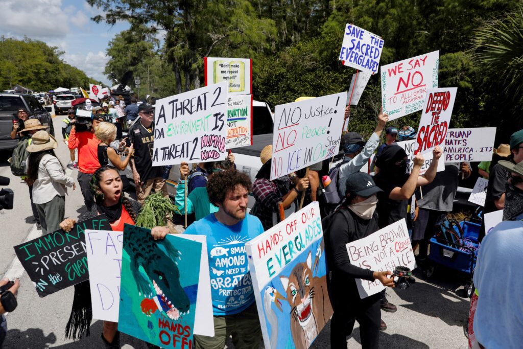 Manifestantes se sitúan a ambos lados de una vía de acceso a un centro temporal de detención de migrantes apodado "Alligator Alcatraz" en Ochopee, Florida, el 1 de julio de 2025, día en que el presidente de EE.UU., Donald Trump, visitó las instalaciones. Líderes católicos están reaccionando ante un informe del Inspector General del Departamento de Seguridad Nacional que revela que "Alligator Alcatraz" confinaba a los migrantes detenidos en celdas de 4 por 7 pies, entre otras prácticas "inhumanas" llevadas a cabo en dicho centro de Florida, que ya ha sido clausurado. (OSV News/Octavio Jones, Reuters)
