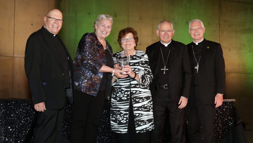 Marge Graf, asesora jurídica general de la arquidiócesis, recibe el premio Evangelii Gaudium de manos de Heather Banis y el arzobispo José H. Gomez el 19 de septiembre. También aparecen en la foto el obispo Matthew Elshoff (derecha), quien fue maestro de ceremonias del evento, y el padre Leon Hutton, rector del Seminario St. John’s en Camarillo. (Belle N’ Beau Photography)