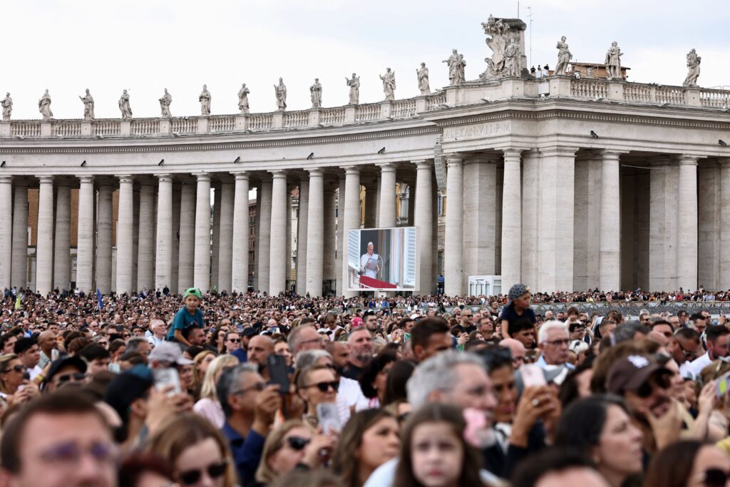 Fieles se reúnen en la plaza de San Pedro mientras el papa León XIV dirige la oración del Ángelus desde una ventana del Palacio Apostólico, tras recibir el alta hospitalaria luego de una cirugía por cáncer de pulmón, en el Vaticano, el 18 de octubre de 2026. (Foto de OSV News/Matteo Minnella, Reuters)
